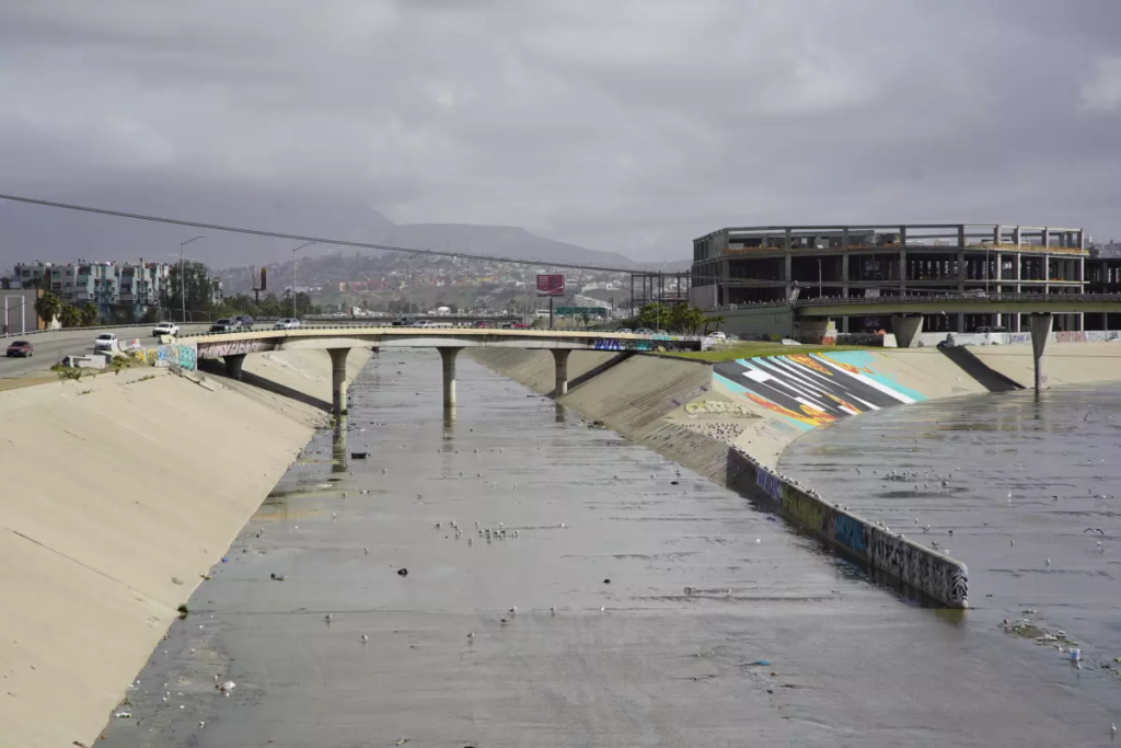 Vista aérea del tramo canalizado del río Tijuana, con aguas estancadas y basura, que se extiende hacia la frontera entre México y Estados Unidos. Fotografía: The San Diego Union-Tribune.