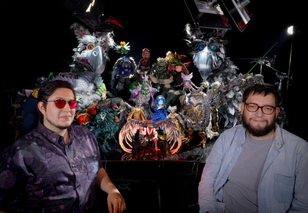 Roy y Arturo Ambriz, directores de "Soy Frankelda", posan frente a varias de las intrincadas marionetas y sets utilizados en la película.