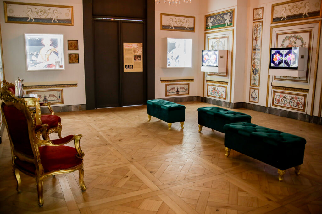 Interior restaurado del Museo del Cacao y Chocolate, mostrando paredes con frescos coloniales, piso de madera de parquet y bancos modernos para los visitantes.