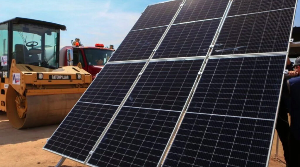 Paneles solares instalados en una estructura metálica junto a maquinaria pesada de construcción Caterpillar en la carretera Mexicali-San Felipe.