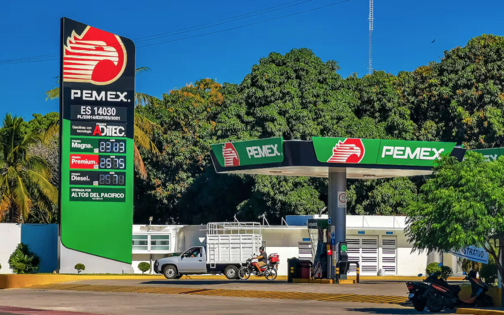Fachada de una estación de servicio Pemex en Puerto Escondido, Oaxaca, mostrando los precios de los combustibles bajo el cielo despejado. Foto: Getty Images.