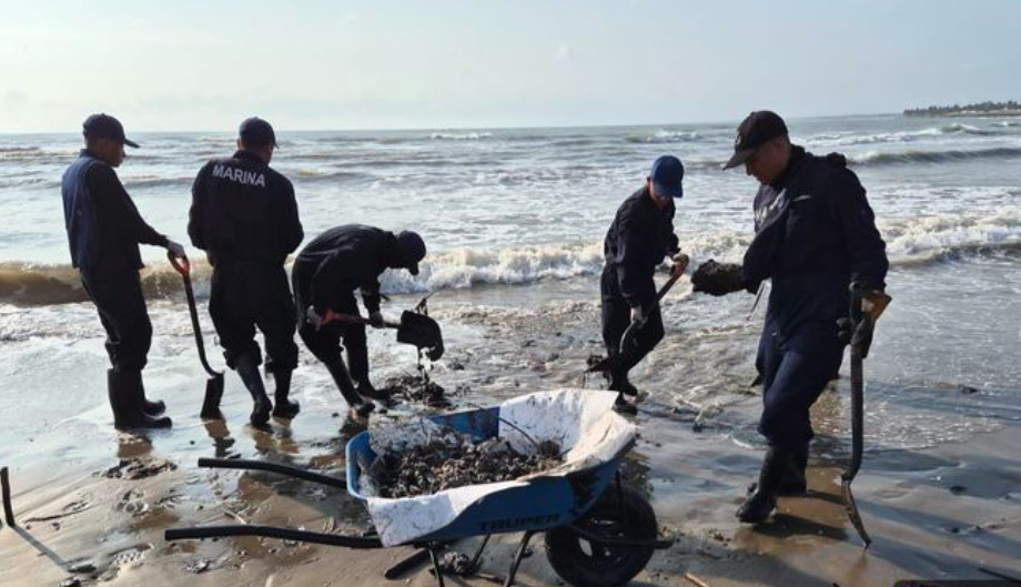 Personal de la Secretaría de Marina (Semar) utilizando palas y carretillas para limpiar residuos de hidrocarburos en una playa del Golfo de México.