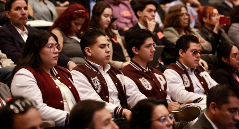 Estudiantes de posgrado con chamarras institucionales del IPN sentados en un auditorio, mostrando preocupación durante una exigencia de transparencia sobre sus becas.