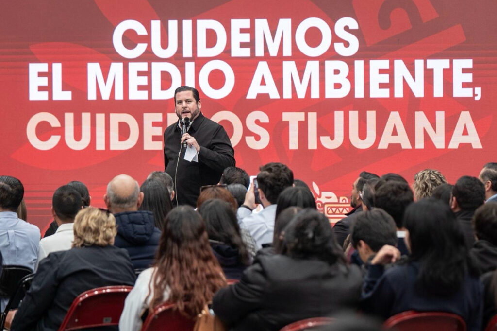 El presidente municipal Ismael Burgueño Ruiz en el podio durante el lanzamiento del programa ambiental en Tijuana, frente a una audiencia de miles de jóvenes estudiantes.