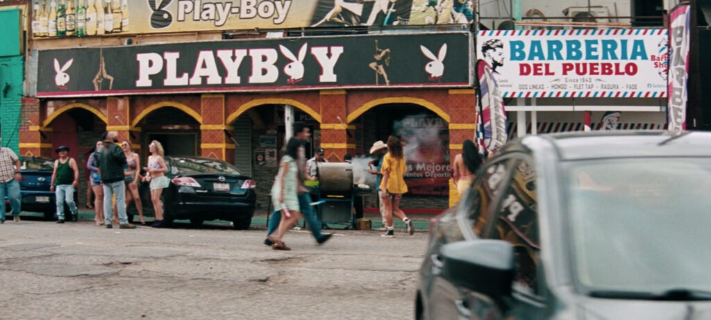 Zendaya en el papel de Rue Bennett, con su característica sudadera granate y expresión melancólica, caminando por una calle de Mexicali durante el rodaje de Euphoria T3.