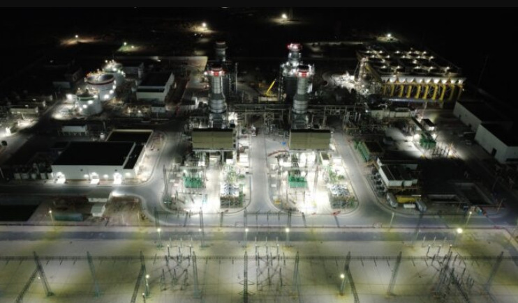 Vista aérea nocturna e iluminada de la planta de ciclo combinado González Ortega, mostrando sus torres de generación, subestaciones eléctricas y tanques de almacenamiento.
