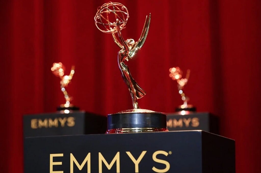 Estatuilla dorada de los Premios Emmy sobre un podio negro con letras doradas frente a un telón rojo durante la 78.ª edición de los galardones.