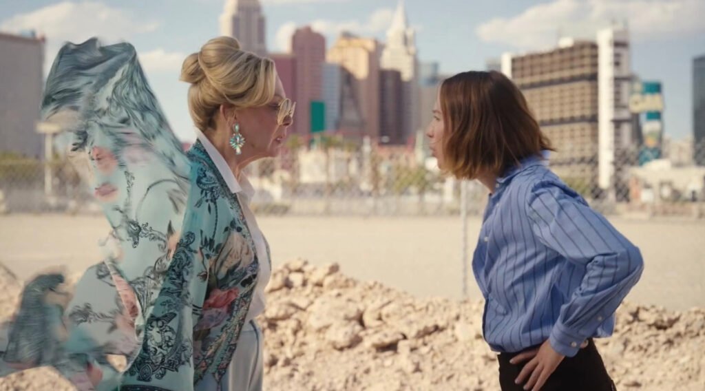Fotograma de la serie Hacks de HBO Max mostrando una confrontación frente a frente entre Jean Smart luciendo un kimono estampado y Hannah Einbinder en camisa azul.