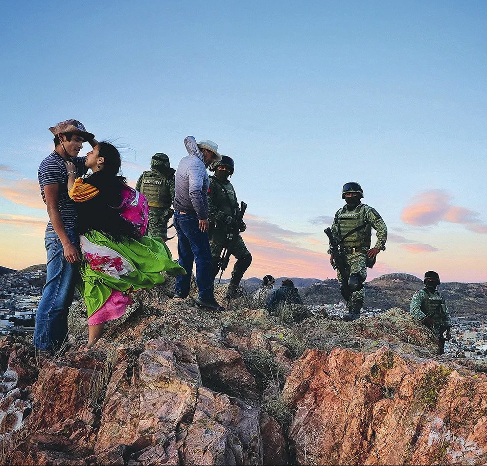 Detalle de la fotografía Makwipa en el equinoccio de Flor Guadalupe Núñez Castañeda con una pareja joven y elementos del Ejército en una colina de rocas.