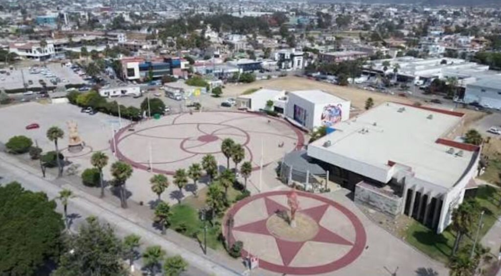 Toma aérea del complejo arquitectónico del CEARTE Ensenada, destacando sus plazas circulares con diseños geométricos, edificios culturales y áreas contiguas.