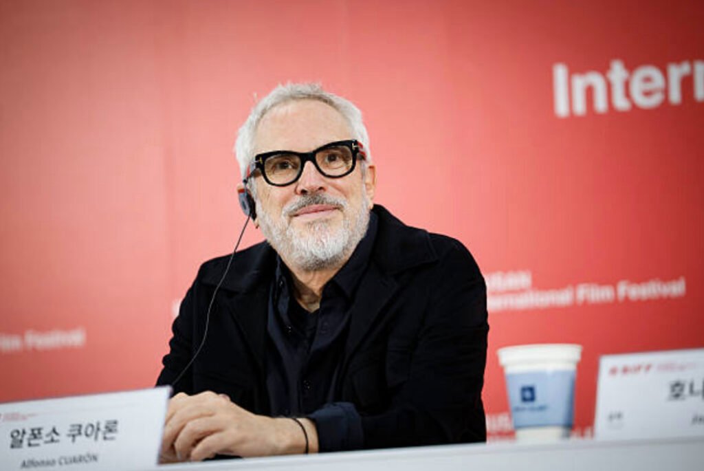 El cineasta mexicano Alfonso Cuarón sonriendo durante una conferencia de prensa en un festival internacional de cine.